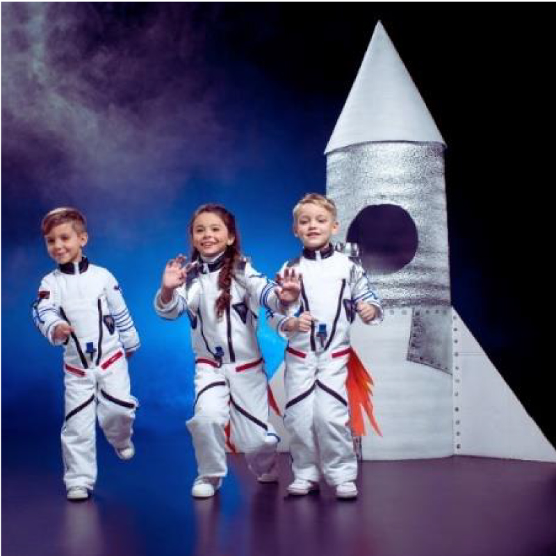 young kids dressed as astronauts with a play spaceship